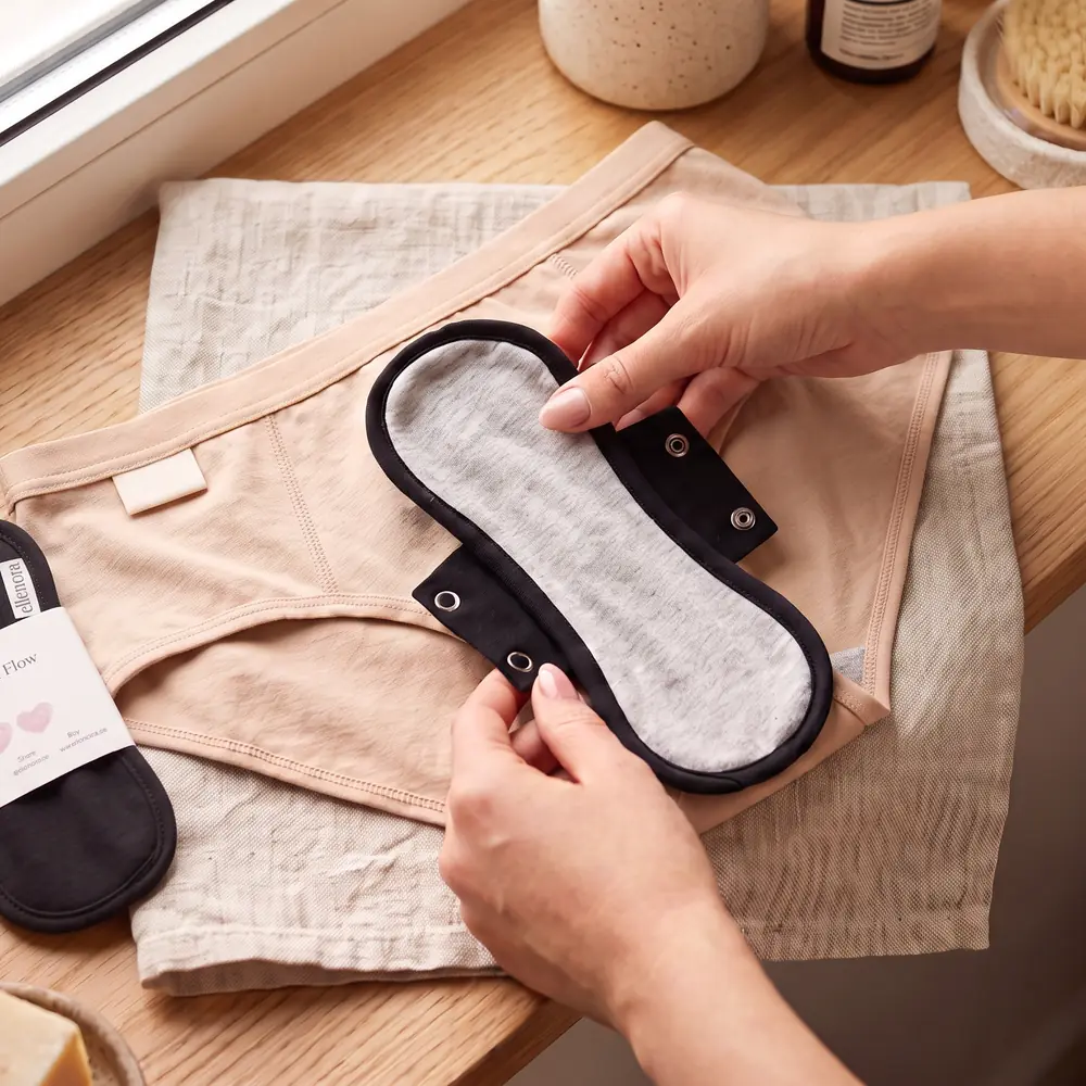 Die Binde wird mit zwei nickelfreien Druckknöpfen in der Unterhose befestigt